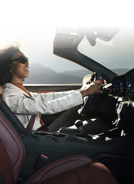 Person sitting in the driver’s seat of a 2024 Ford Mustang® convertible | Banister Ford of Marlow Heights in Suitland MD